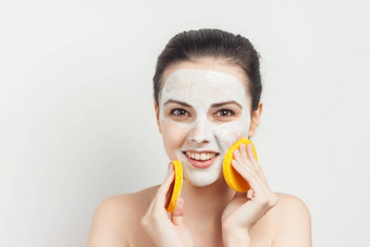 快乐的浅黑肤色的女人湿巾面具海绵擦洗护肤品