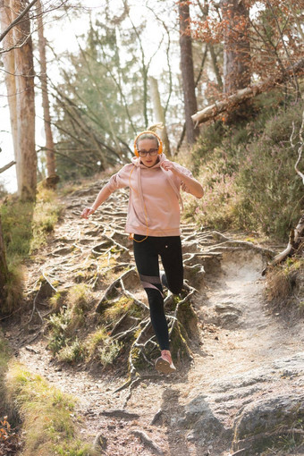 <strong>活跃</strong>的运动女人运行秋天秋天森林跳根路径健康的生活方式图像年轻的<strong>活跃</strong>的高加索人女人慢跑自然