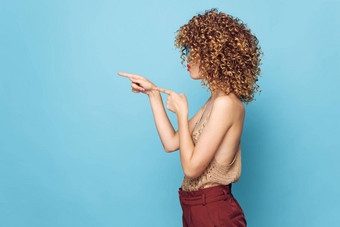 女人肖像卷曲的头发一边视图手势手指复制空间棕色（的）裤子