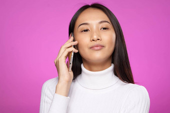 女人亚洲外观会说话的电话生活方式技术粉红色的背景工作室