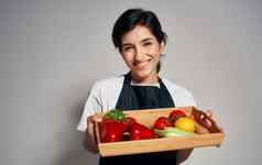 女人老板黑色的围裙切片蔬菜烹饪食物健康的食物家庭