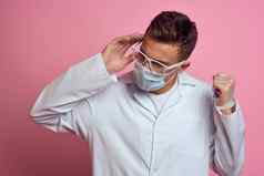 医生白色外套医疗面具治疗健康专业粉红色的背景