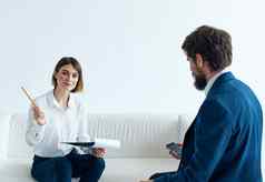 女人沙发在室内心理学家沟通男人。西装