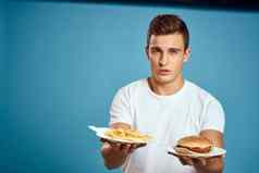 男人。穿白色t恤汉堡饮食快食物蓝色的背景