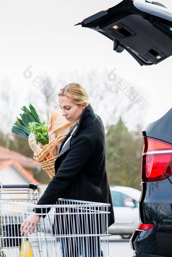 女人加载食品杂货购物树干车