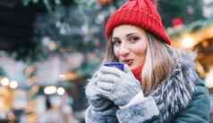 女人前面圣诞节树冬天市场喝热酒