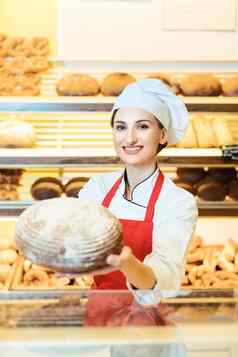 女售货员围裙展示新鲜的面包面包店商店
