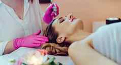 美容师给女人皮肤治疗激光技术