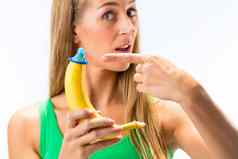 女人显示香蕉蓝色的避孕套