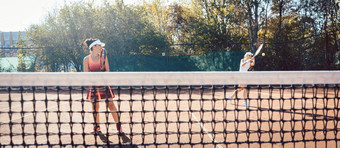 女人红色的体育运动衣服玩<strong>网球</strong>