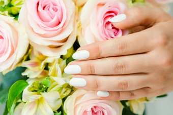 指甲年轻的女人白色修指甲玫瑰花