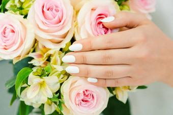指甲年轻的女人白色修指甲玫瑰花