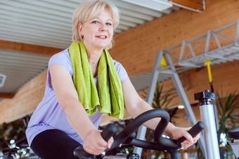 高级女人锻炼自行车健身房