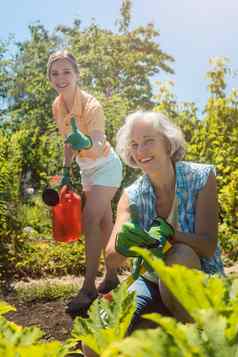 高级女人工作蔬菜女儿浇水花园