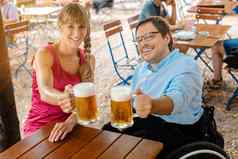禁用男人。轮椅朋友喝啤酒