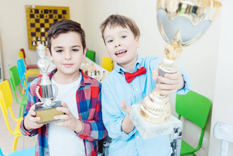 男孩赢得了国际象棋比赛持有奖杯