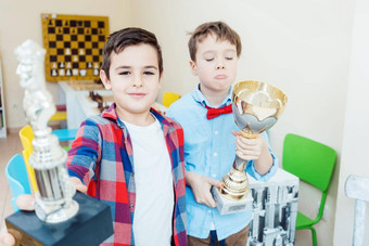 男孩<strong>赢得</strong>了国际象棋比赛持有奖杯