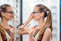 年轻的女人验光师商店检查镜子