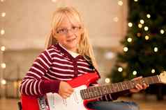 女孩吉他前面圣诞节树