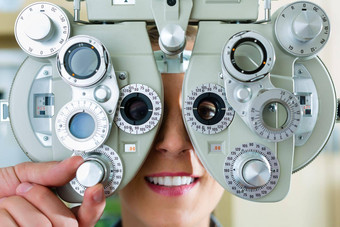 年轻的女人综合屈光检查仪眼睛测试