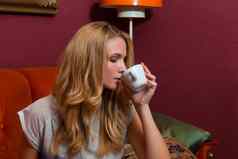 年轻的女人喝咖啡卡布奇诺咖啡