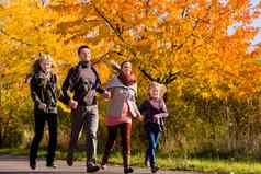 家庭走前面色彩斑斓的树秋天