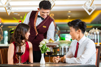 中国人服务员服务晚餐优雅的餐厅酒店