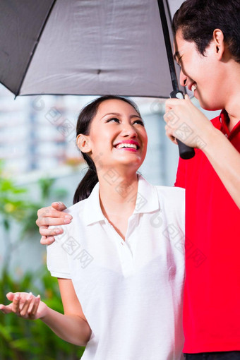 亚洲夫妇走伞雨