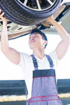 亚洲中国人车机械师改变汽车轮胎