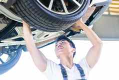 亚洲中国人车机械师改变汽车轮胎