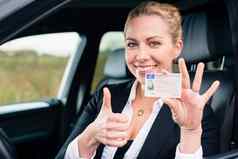女人显示开车许可证拇指
