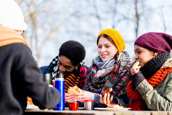 年轻的朋友会说话的野餐在户外公园