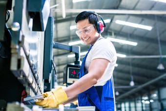 工业工人检查工作一块站工厂地板上耳朵耳罩护目镜
