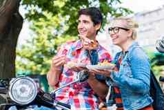 旅游夫妇采取休息踏板车之旅吃咖喱香肠