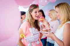 期待妈妈。吃粉红色的蛋糕婴儿淋浴聚会，派对