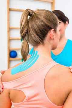 女人基尼西奥磁带肩膀物理治疗