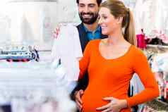 怀孕了女人男人。购买婴儿衣服商店