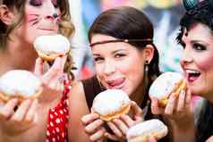 女孩德国狂欢节狂欢节吃甜甜圈状的传统的糕点