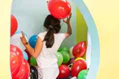 可爱的女孩玩色彩斑斓的气球游戏时间幼儿园