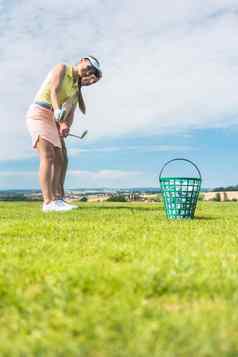 年轻的女人练习正确的移动高尔夫球类