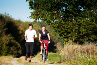 年轻的体育运动夫妇慢跑骑自行车