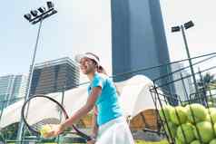 快乐的美丽的女人玩网球发达城市