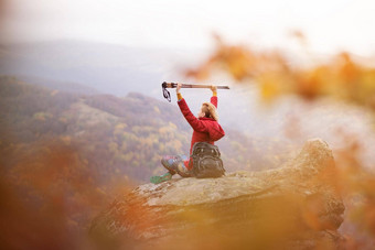 徒步<strong>旅行</strong>者女孩<strong>坐</strong>着岩石山享受视图手持有徒步<strong>旅行</strong>波兰人<strong>旅行</strong>健康的生活方式在户外秋天季节