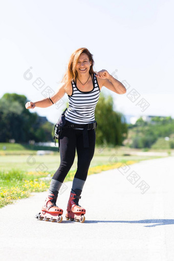 辊滑冰女孩沥青路在户外热夏天一天