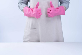 年轻的女人<strong>管家</strong>围裙穿粉红色的手套清洁表格概念防止病毒感染<strong>管家</strong>服务关闭