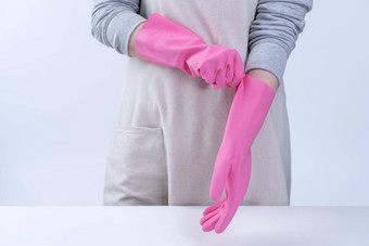 年轻的女人管家围裙穿粉红色的手套清洁表格概念防止病毒感染管家服务关闭