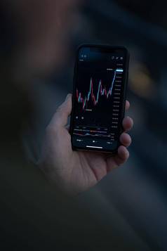 商人交易员股票市场数据智能手机屏幕分析外汇图表