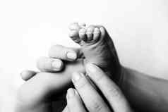 孩子们的脚持有手妈妈。父亲白色妈妈。父亲新生儿孩子快乐家庭人概念黑色的白色