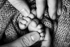 孩子们的脚持有手妈妈。父亲白色妈妈。父亲新生儿孩子快乐家庭人概念黑色的白色