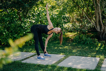 活跃的健身模型练习在户外倾斜脚提出了手臂准备肌肉有氧运动培训<strong>挑战</strong>穿着活跃的穿小马尾巴提出了绿色公园阳光明媚的一天